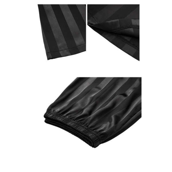 Zwarte gestreepte broekspijp met elastische zoom en detailopname van de naden, stijlvol en elegant ontwerp.