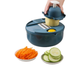 Handrasp snijdt groenten in kom, met komkommers en wortelschaafsel op borden, voor makkelijk en snel koken.
