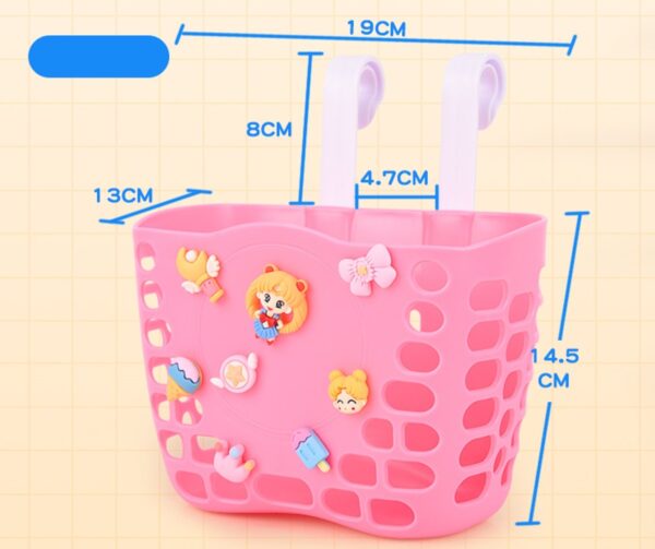 Roze fietsmand met decoratieve figuren en afmetingen, ideaal voor kinderfietsen. Afmetingen: 19x13x14.5 cm.