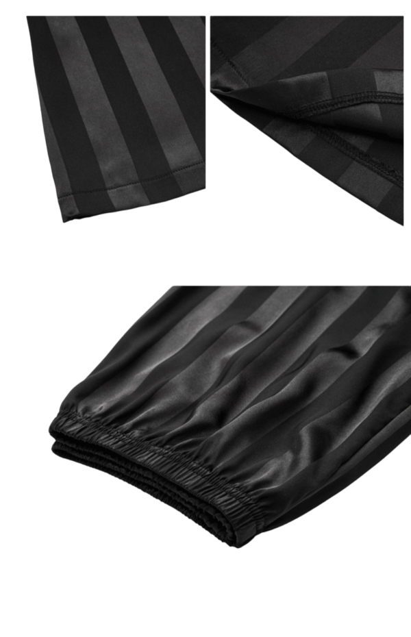 Zwart gestreepte satijnen slaapkleding met elastische boorden, detailopname van mouw en pijp. Luxe nachtkleding.