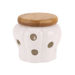 Witte keramische pot met bamboedeksel en ronde openingen, geschikt voor keuken of decoratie.