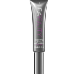 Grijze Huda Beauty wimperlijm tube, geschikt voor het bevestigen van kunstwimpers, 7 g inhoud.