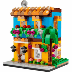 Kleurrijk LEGO-huis met plantendecoratie en palmboom, ideaal bouwproject voor kinderen en verzamelaars.