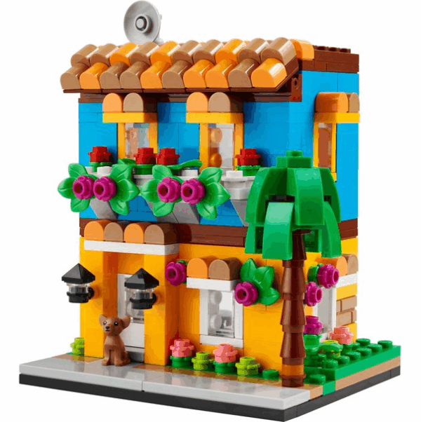 Kleurrijk LEGO-huis met plantendecoratie en palmboom, ideaal bouwproject voor kinderen en verzamelaars.
