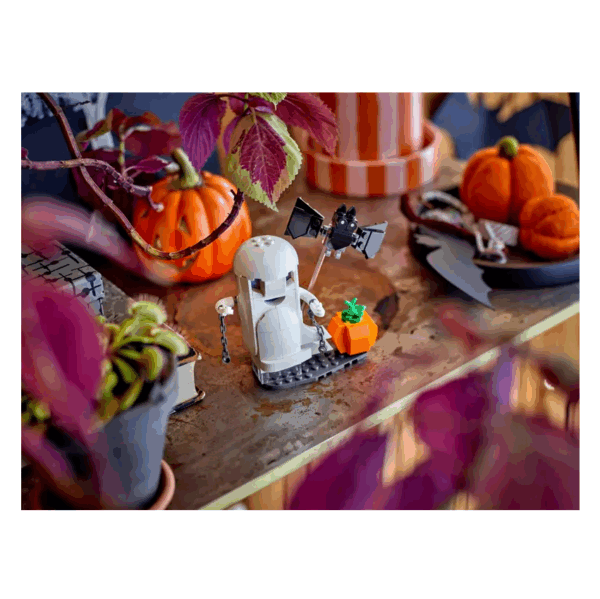LEGO-spook met pompoen en vleermuis op een herfstdecoratie vol sfeervolle Halloween-elementen.