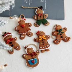 Gemberkoekjes kerstversieringen in verschillende stijlen op een tafel, klaar om opgehangen te worden. Feestelijk decor.