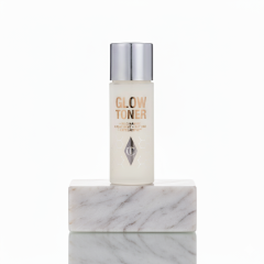 Glow Toner fles op marmeren blok, huidverzorging met niacinamide en peptiden voor een stralende teint.