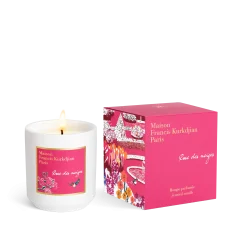 Geurkaars Rose des neiges van Maison Francis Kurkdjian in roze verpakking, brandend met vlam.