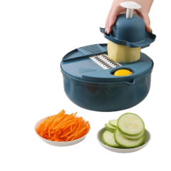 Handrasp snijdt groenten in kom, met komkommers en wortelschaafsel op borden, voor makkelijk en snel koken.