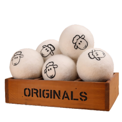Wollen drogerballen met schapenmotief in een houten kist, perfect voor milieuvriendelijk en zacht drogen van kleding.