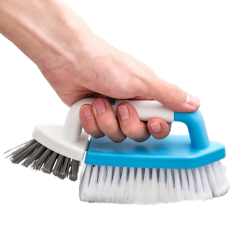 Hand houdt een schoonmaakborstel met blauw handvat vast, ideaal voor huishoudelijke schoonmaakklussen.