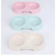 Drie kleurige dubbele voerbakjes voor huisdieren: roze, blauw en beige. Perfect voor katten en honden.
