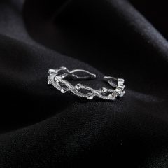 Elegant zilveren ring op zwarte stof, fijn gedetailleerd met bloemmotieven, perfect als verfijnd sieradencadeau.