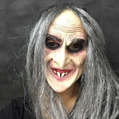 Persoon in realistisch heksenmasker, met grijs haar en lachend gezicht, voor Halloween of themafeesten.
