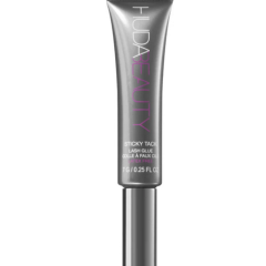 Grijze Huda Beauty wimperlijm tube, geschikt voor het bevestigen van kunstwimpers, 7 g inhoud.
