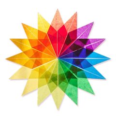 Kleurrijke geometrische stervormige figuur van gevouwen papier in regenboogtinten, stralend op een witte achtergrond.